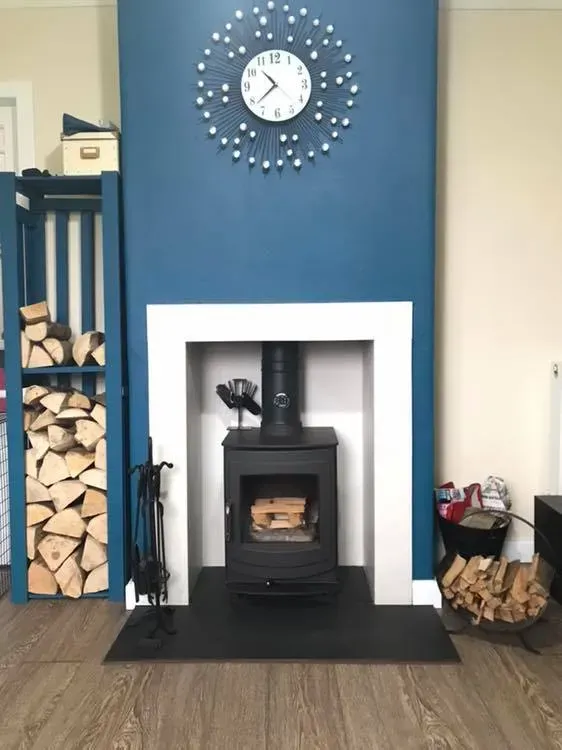 Wood burning stove in a blue chimney breast with log store by Agnew Chimney Engineering Glasgow