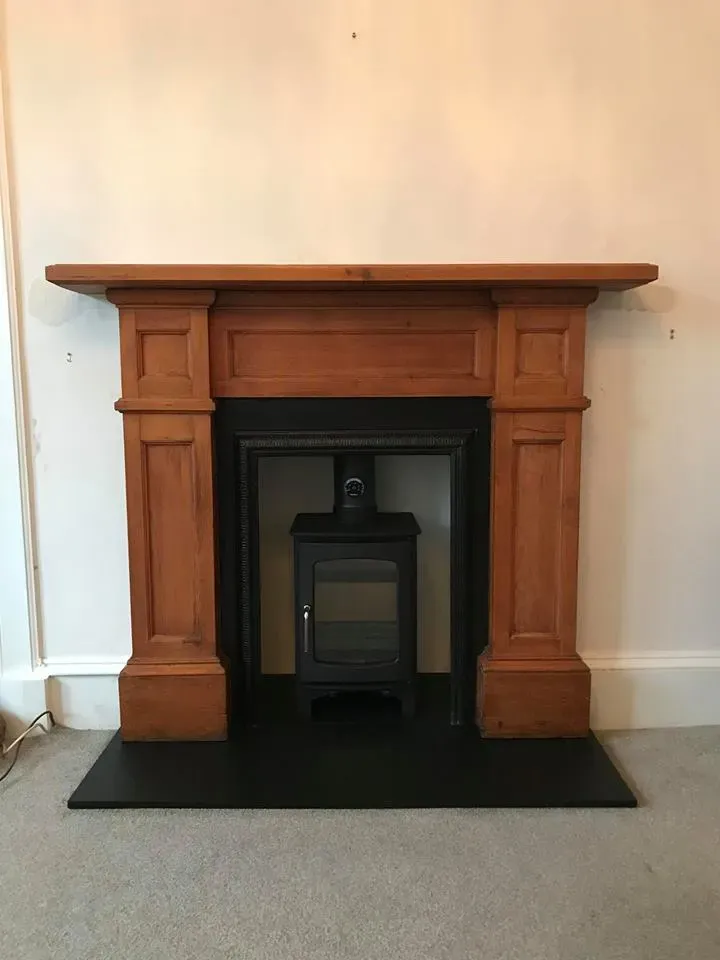 Stove fitted in a traditional wooden fireplace surround by Agnew Chimney Engineering Glasgow