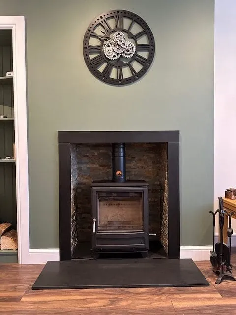 Stove set into a dark brick recess by Agnew Chimney Engineering Glasgow