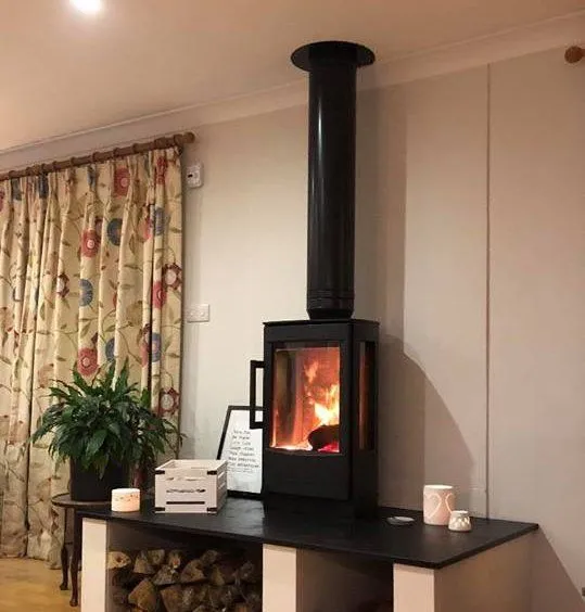 Tall contemporary stove lit in a living room by Agnew Chimney Engineering Glasgow